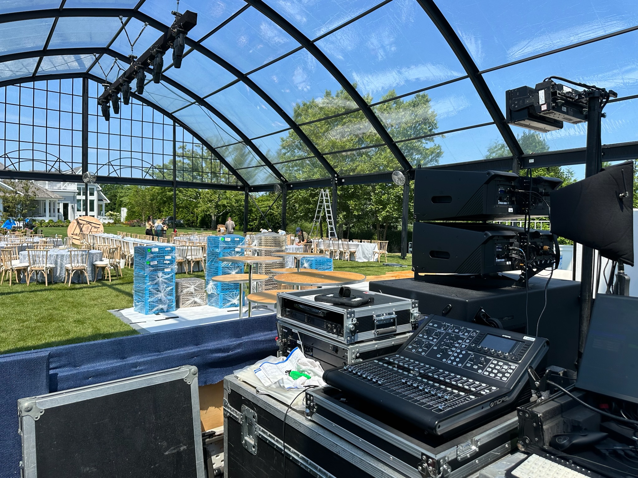 Outdoor control booth under a canopy at a live event setup.